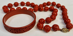 Lot 299 - Vintage Chinese red cinnabar bangle & long string beads
