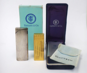 Lot 293 - 2 x Vintage Tiffany & Co Cigarette Lighters - Gold and Silver Tone