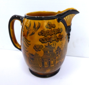 Lot 307 - C 1902 Royal Doulton Jug - black on mustard Willow Pattern, Numbered D