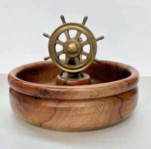 Lot 334 - Large turned peppercorn nut cracker Bowl with brass ship's wheel clamp