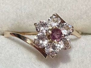 Lot 126 - Dainty 14 ct gold ring - floral setting with small ruby to centre and