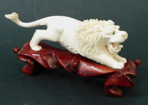 Lot 189 - Vintage Non Composite Lion figure on carved wooden stand 8cm H