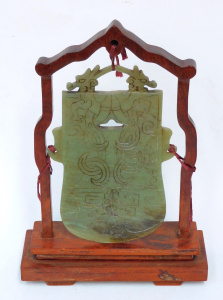 Lot 201 - Chinese green stone archaic style dragon carved plaque in timber stand