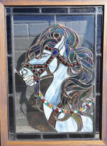 Lot 011 - Framed stained glass window depicting a horse head with ruby glass dro