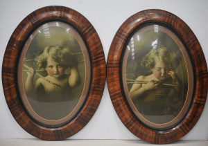 Lot 110 - Oval framed prints of Cupid Awake, Cupid Asleep under convex bubble gl
